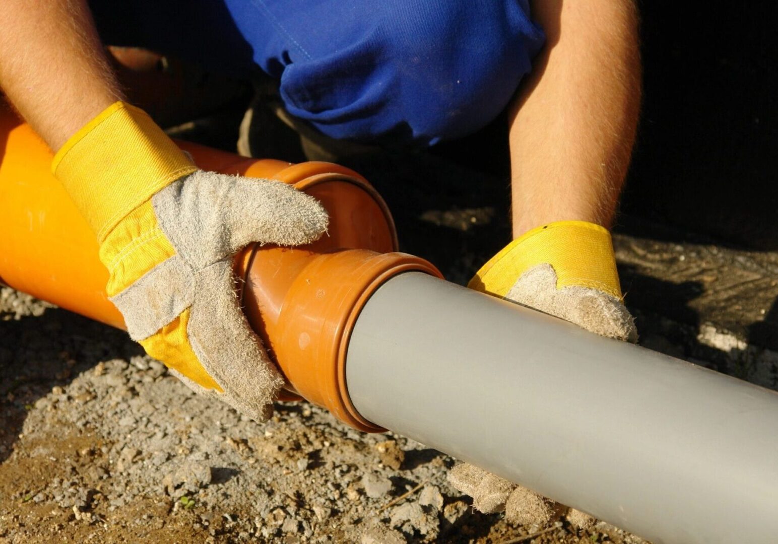 A plumber fixing an underground pipe